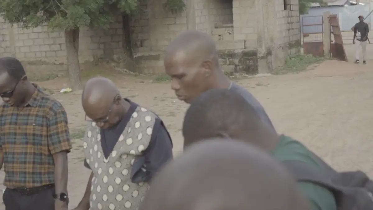 A clinician in green scrubs seated with a patient during the Sumana Village outreach in Kano State.